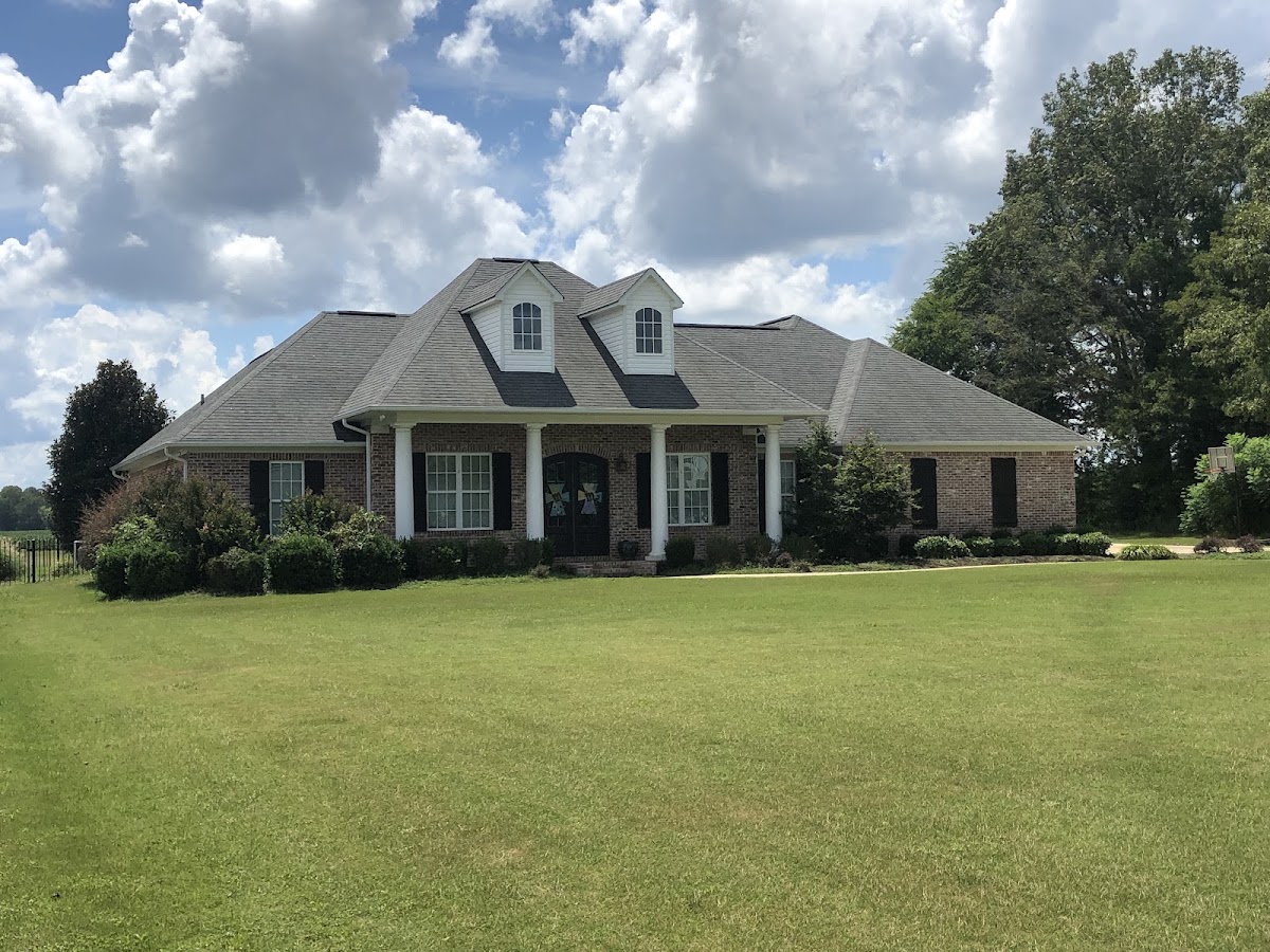 Clean brick ranch home with a wide green lawn